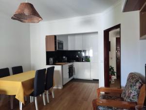 a kitchen and dining room with a table and chairs at Caparica Apartment near beach in Costa da Caparica