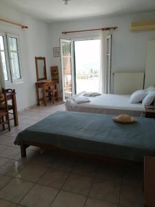 a bedroom with two beds and a large window at Lontza Apartments in Lazaráta