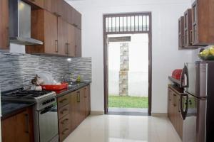 a kitchen with wooden cabinets and a stove top oven at Arazia in Panadura