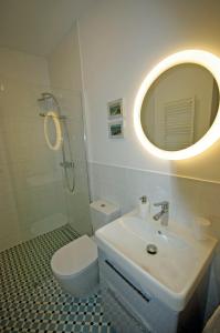 ein Badezimmer mit einem Waschbecken, einem WC und einem Spiegel in der Unterkunft Błękitny domek in Darłowo