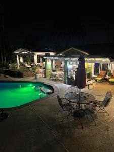 a swimming pool at night with a table and an umbrella at Beautiful Foothill Living in Rancho Cucamonga