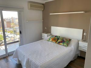um quarto com uma cama com uma colcha branca e uma janela em BALCÓN AL RíO PARANÁ em Paraná