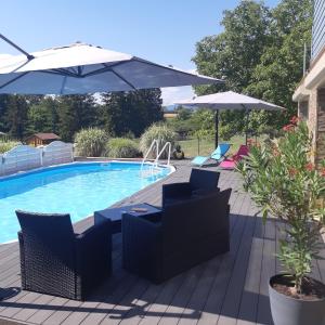 a pool with chairs and umbrellas on a deck at Suite cocooning - Route des Vins in Bergbieten