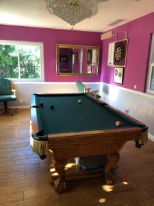 a pool table in a room with purple walls at Beautiful Foothill Living in Rancho Cucamonga