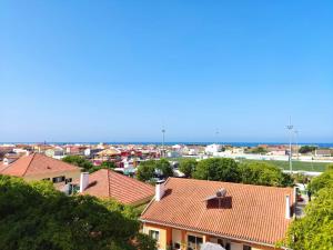 a view of roofs of houses and the ocean at Caparica Apartment near beach in Costa da Caparica