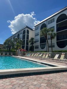 a swimming pool in front of a building at Knot a Care Remodeled Direct water access condo with ocean and pool views NOW SLEEPS SIX in Marco Island