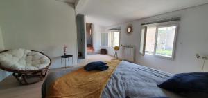 a bedroom with a bed and a chair and a window at LA MUSCADELLE : le calme du sud de la France in Marseillette +65 photos
