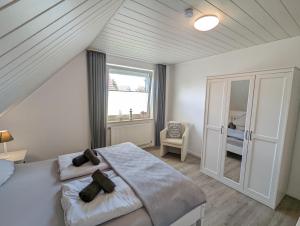 a bedroom with a large bed and a window at Das Inselhaus in Norddeich