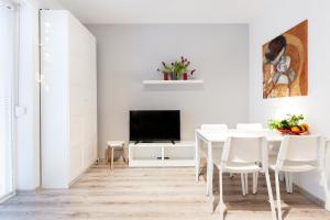 comedor blanco con mesa y TV en Project Comfort Apartament Dywizjonu 303 175/8 Warszawa, en Varsovia
