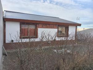 un edificio blanco con dos ventanas y un cartel en él en Mi Refugio en Río Gallegos