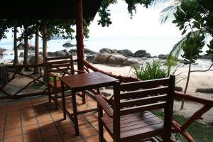 Sea Scene Resort في ووك توم: كرسيين وطاولة على الشاطئ