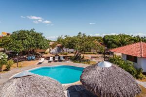 a resort with a swimming pool and two straw umbrellas at Pousada Juventus in Barra Grande