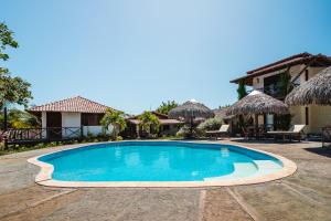 a swimming pool in front of a house at Pousada Juventus in Barra Grande