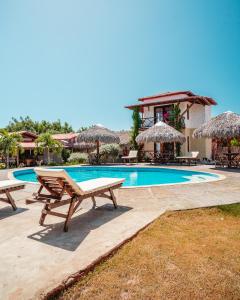 - une piscine avec des tables de pique-nique et des parasols dans l'établissement Pousada Juventus, à Barra Grande