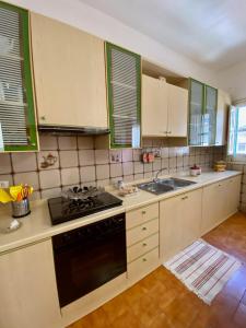 a kitchen with white cabinets and a black stove top oven at Casa Tanina in Scordia
