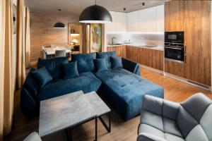 Il comprend un salon avec un canapé bleu et une cuisine. dans l'établissement Hillside Y41, à Dolný Kubín