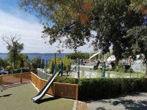 a playground with a slide in a park at Mobile Home Aurora Selce in Selce +35 photos