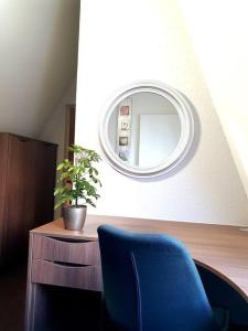 a room with a blue chair and a mirror at Rostock hautnah erleben - schöne Maisonette 2OG in Rostock