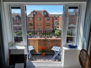 a large window with a view of a building at HighTide - 2 bed with parking, balcony & sea view. in Swanage