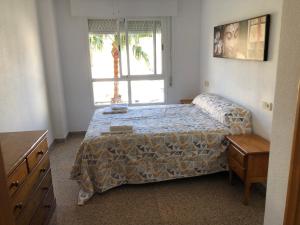 1 dormitorio con cama y ventana en Precioso apartamento en Urbanización junto al mar., en Alicante