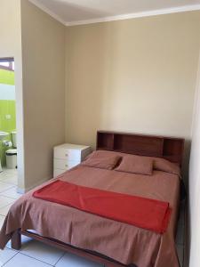 a bedroom with a large bed with a red blanket at Dpto Bolivar Hermoso, amplio y bien ubicado en la chura Tarija in Tarija