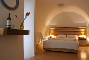 a bedroom with a white bed and a vase with flowers at Casa Maria Hotel Apts in Platanias