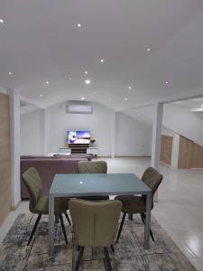 a dining room with a table and chairs and a television at Anton Lux Apartment in Kočani