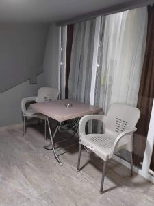 a table and chairs in a room with a window at Anton Lux Apartment in Kočani