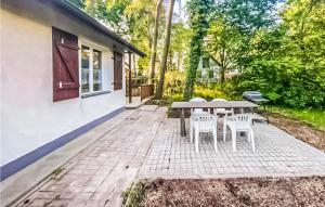 a patio with a table and chairs next to a house at Lovely Home In Kamionki Male With Kitchen in Kamionki Małe