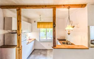 een keuken met witte kasten, een wastafel en een raam bij Lovely Home In Kamionki Male With Kitchen in Kamionki Małe