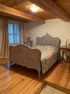 een slaapkamer met een bed en een houten vloer bij La Maison Rose in Caromb