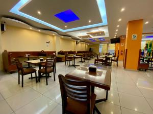 a dining room with tables and chairs in a restaurant at Hotel Las Palmeras in Huacho