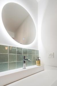 uma casa de banho com um lavatório e um espelho em A modern flat in the center of Fontainebleau em Fontainebleau