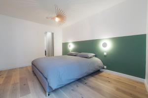 a bedroom with a bed and a green wall at A modern flat in the center of Fontainebleau in Fontainebleau