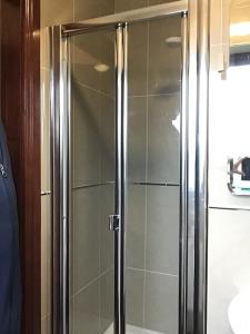 een douche met een glazen deur in de badkamer bij Errew Lodge in Mohill