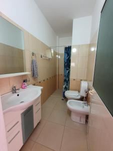 uma casa de banho com um lavatório e um WC em Apartment Emma em Velipojë