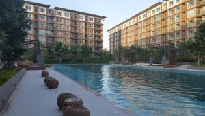 a swimming pool in front of two large buildings at The Relaxing Room Mountain View at Baan Tew Lom Condominium Cha Am - Hua Hin in Cha Am
