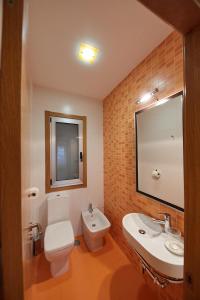 a bathroom with a toilet and a sink and a mirror at Vut Salvador Santiago in Santiago de Compostela