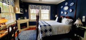 een slaapkamer met blauwe muren, een bed en een open haard bij Pettigru Place Bed & Breakfast in Greenville
