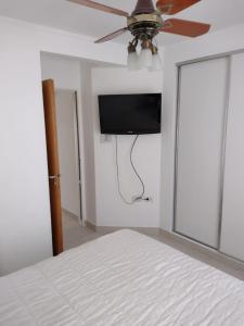 1 dormitorio con ventilador de techo y TV en la pared en Precioso departamento en Paraná. Zona Centro en Paraná