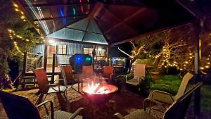 a fire pit in a yard with chairs and lights at Retro Dunes Venus Bay - WiFi, Netflix, BBQ, linens, pets OK in Venus Bay +22 photos