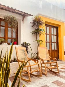 two wicker chairs sitting in front of a house at Hostal 1545 in Ríohacha