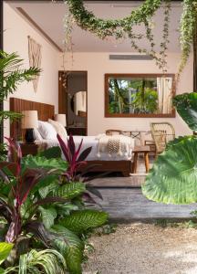 um quarto com uma cama e algumas plantas em MISTIQ Tulum Luxury Apartments em Tulum