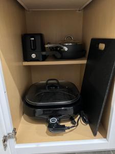 a pot and pan sitting on a shelf in a cabinet at Tiny Home in El Paso