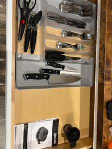 a drawer filled with knives and utensils at Tiny Home in El Paso