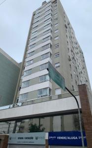 a tall building with a street sign in front of it at Novo apto com garagem no centro de Passo Fundo RS in Passo Fundo