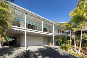 a large white house with palm trees in front of it at Sea Breeze in Elizabeth Beach