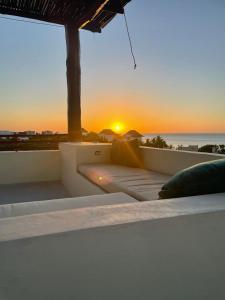 puesta de sol sobre el océano con cama en el balcón en Casa Molly en Holbox Island