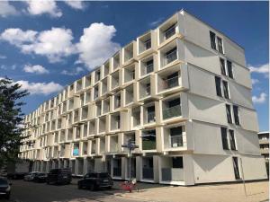ein weißes Gebäude mit davor geparkt in der Unterkunft Myroom Business Apartment Nähe Messe München in München