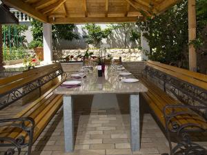 un tavolo seduto su un patio con due panche di Villa Katarina - private Pool 80m from beach a Marina